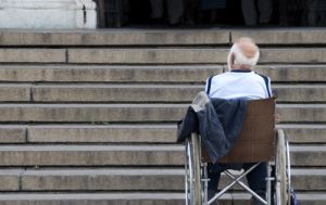 Rohlstuhlfahrer vor einer viel zu hohen Treppe